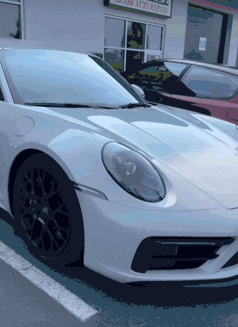 White car with dark tinted windows parked on a residential street, offering enhanced privacy and interior protection