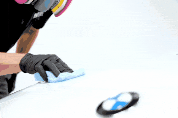 Technician applying ceramic coating to a car’s paint surface with a microfiber cloth