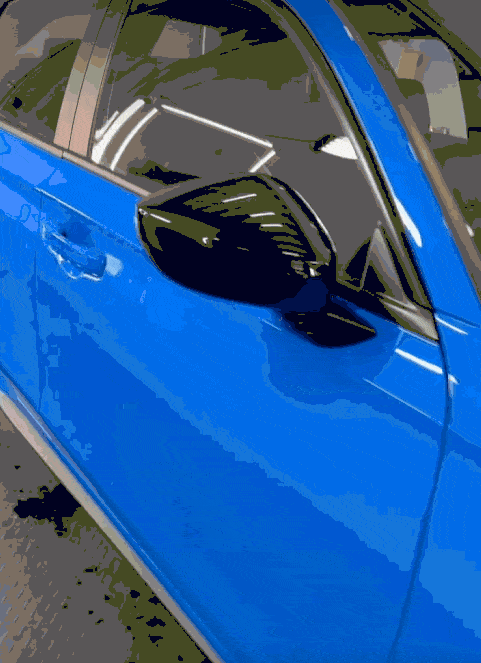Close-up of a glossy blue car door and black side mirror under studio lighting, showing flawless paint protection film or ceramic coating finish