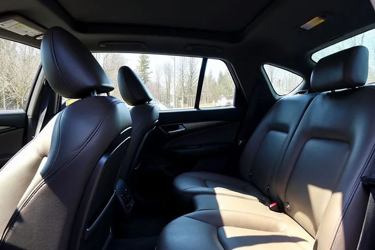 Clean and detailed black leather car interior with sunlight streaming through the windows