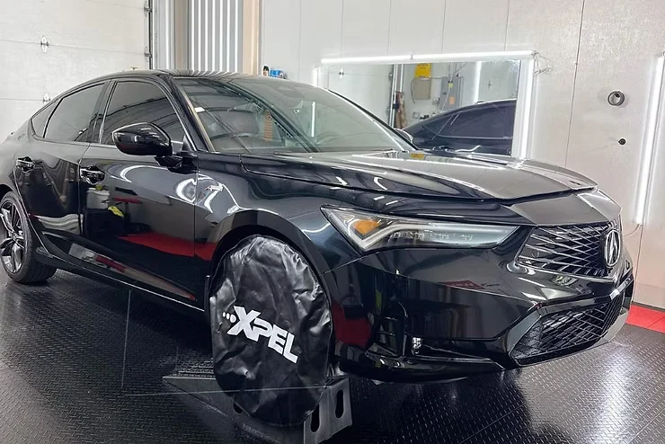 Black SUV with XPEL paint protection film being serviced in a detailing bay