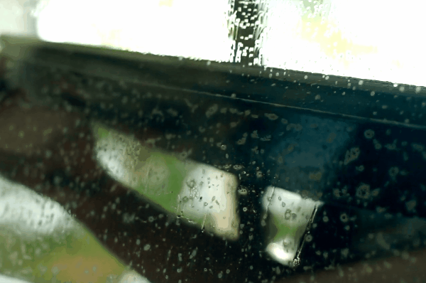Close-up view of window tint film with moisture bubbles during the car window tint installation process