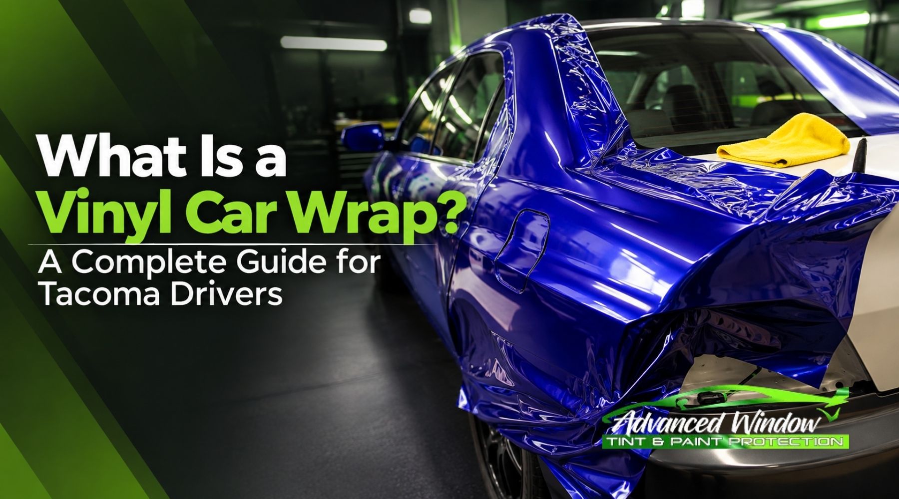Blue car receiving a vinyl wrap installation in an automotive shop with “What Is a Vinyl Car Wrap?” text.